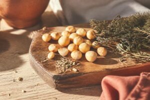 Noix de macadamia dorees sur une planche en bois rustique, lumiere chaude mediterraneenne