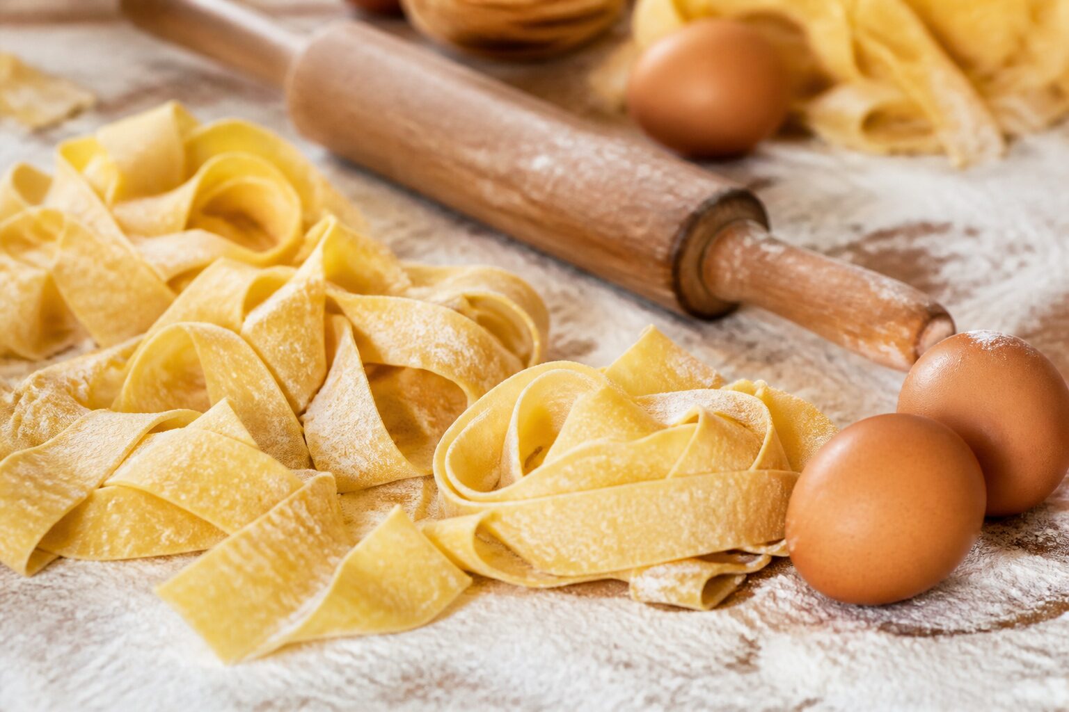 Pappardelle fraîches maison prêtes à cuire sur plan de travail