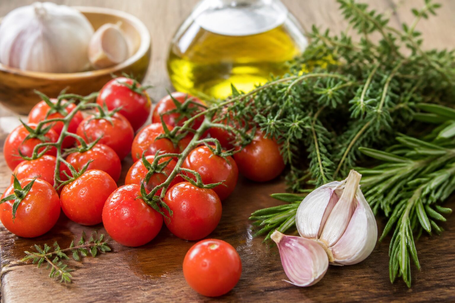 Ingrédients méditerranéens : tomates cerises, thym, romarin, ail et huile d'olive pour recettes faciles et rapides