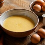 Appareil a quiche versé dans un saladier avec oeufs et crème