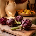 Artichauts violets entiers posés sur une planche en bois avant cuisson à la cocotte minute