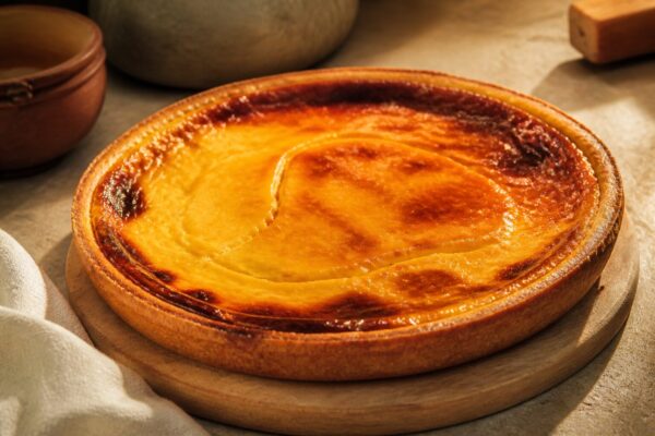 flan parisien entier doré sur planche en bois, lumière naturelle chaude