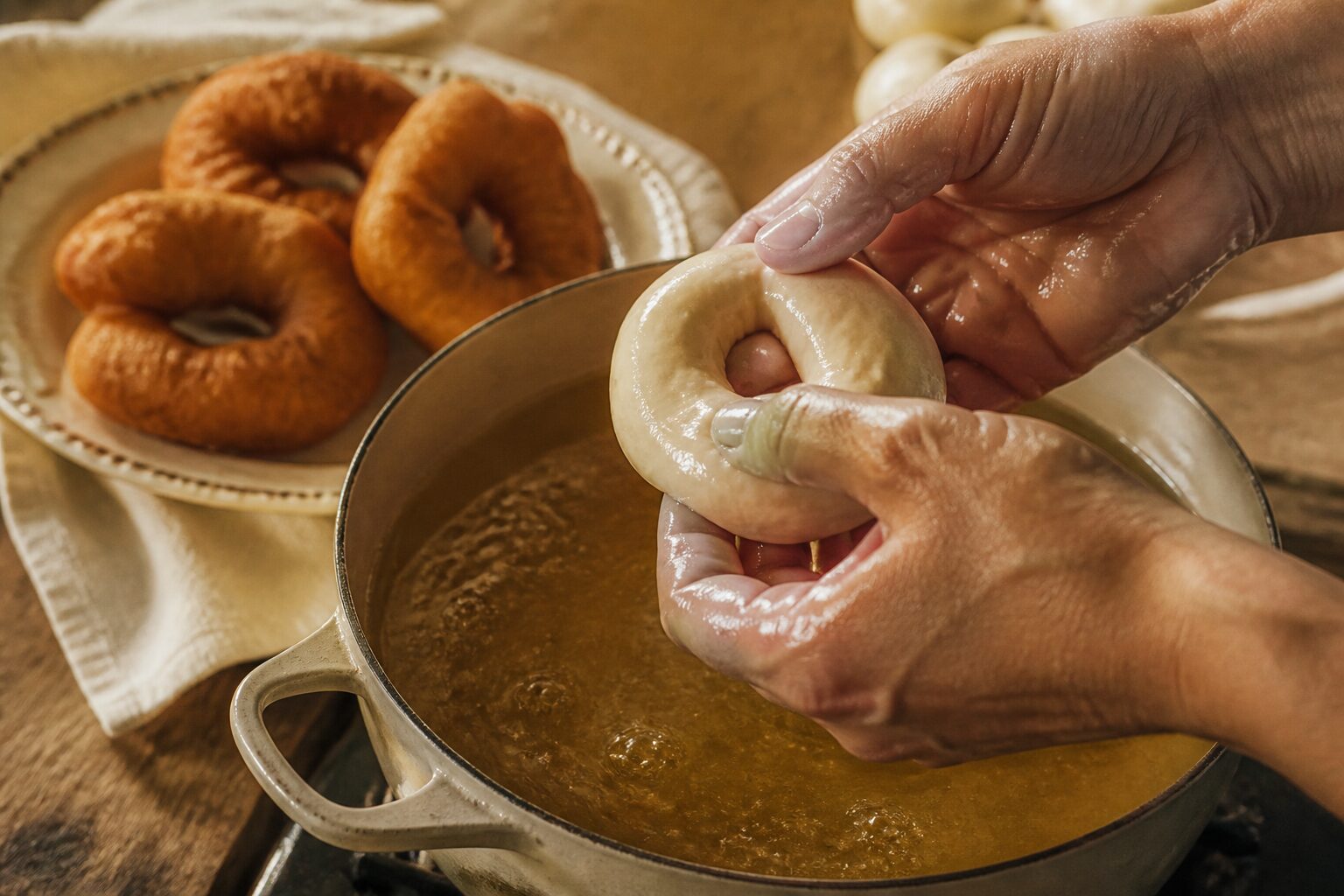 Mains formant un anneau de pâte à sfenj avant friture