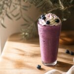 Grimace shake, milkshake violet aux fruits rouges garni de chantilly