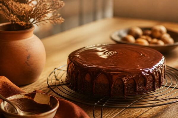 Nappage chocolat brillant coulant sur un gâteau posé sur une grille