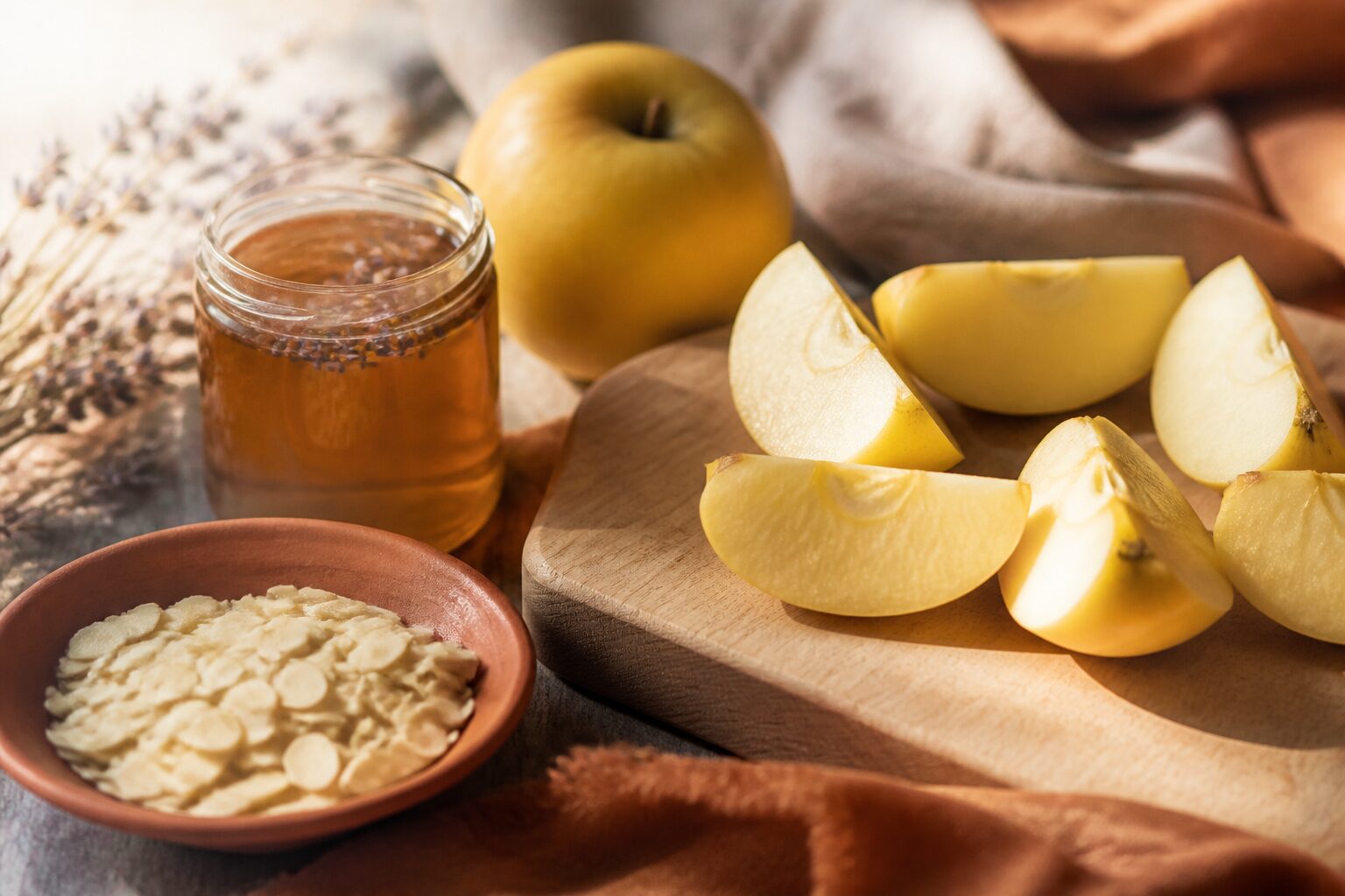 Quartiers de pomme golden avec miel et amandes sur une planche en bois