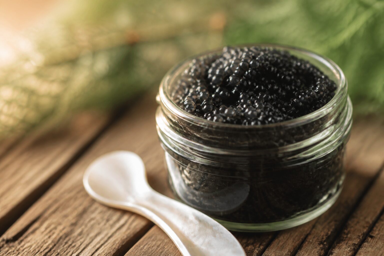 Pot d'oeufs de lompe noirs ouvert avec une cuillère nacrée