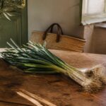 Botte d'oignon cébette fraîche posée sur une table en bois de cuisine provençale