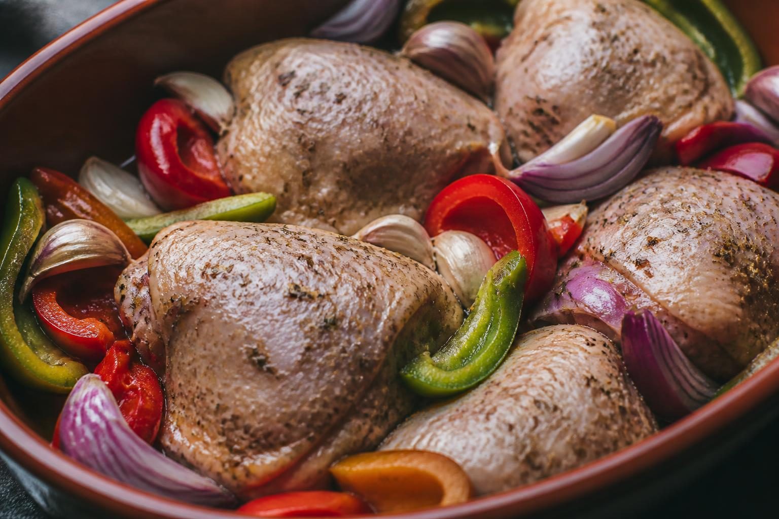 Cuisses de poulet marinées aux herbes de Provence avant cuisson au four avec légumes