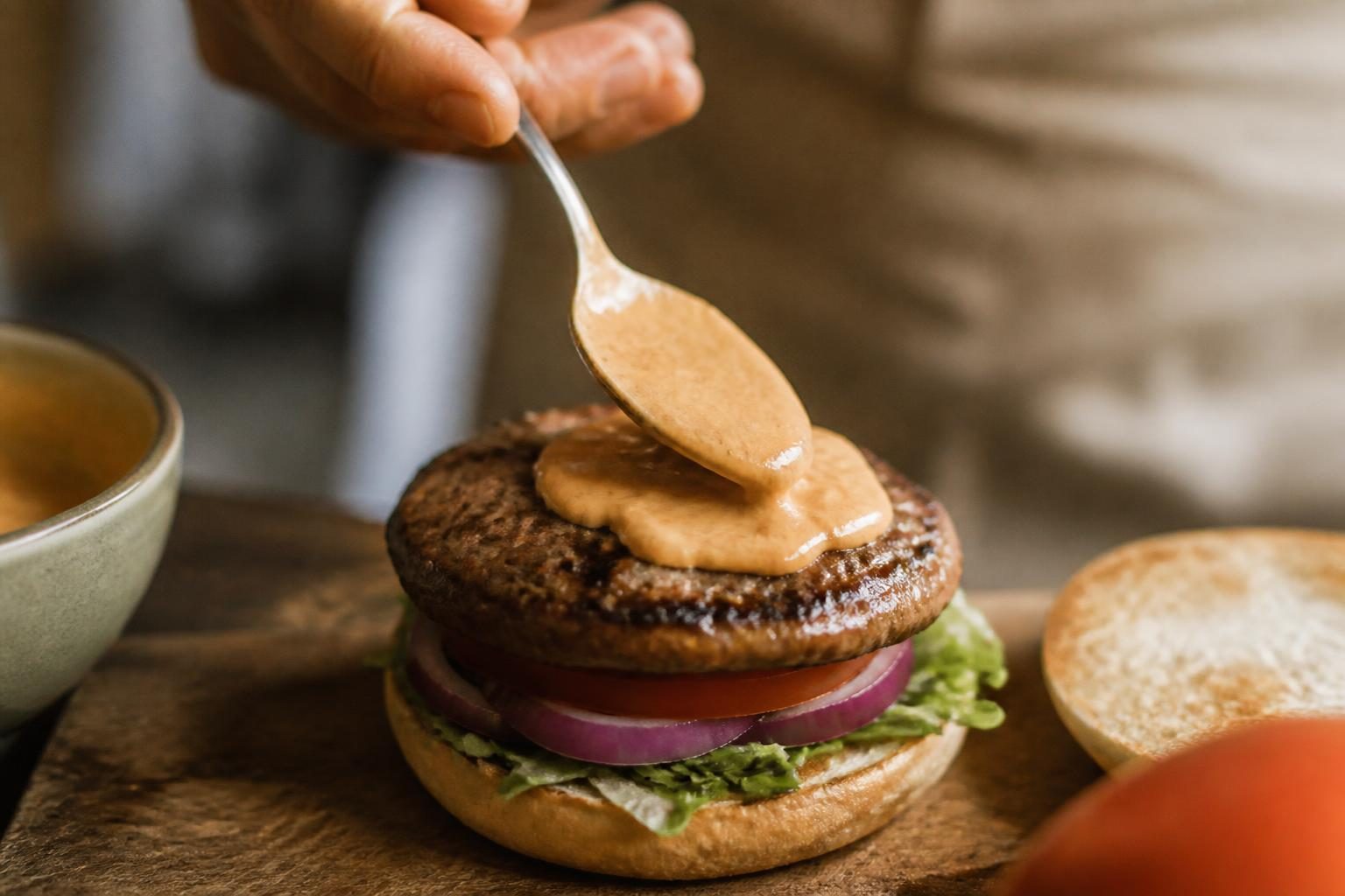 Cuillère nappant un burger de sauce burger américaine maison