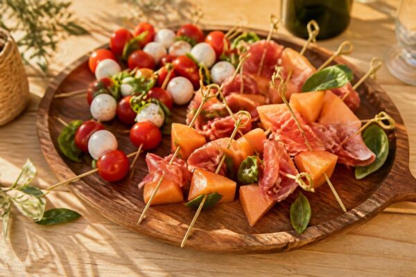Brochettes apéritives variées sur plateau en bois pour l'apéro
