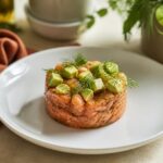 Tartare de saumon frais dressé avec avocat et aneth sur assiette blanche