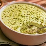 Tiramisu à la pistache crémeux dans un plat, pistaches concassées sur le dessus