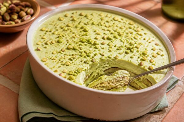 Tiramisu à la pistache crémeux dans un plat, pistaches concassées sur le dessus